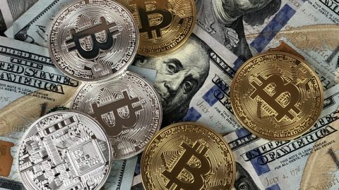 hundred-dollar-bills-and-bitcoin-coin